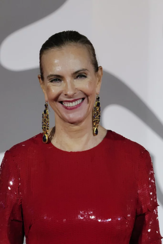 Carole Bouquet smiling on the red carpet in red sequins at Venice Film Festival 2026, Ph. Barbara Pigazzi, Studio Animica
