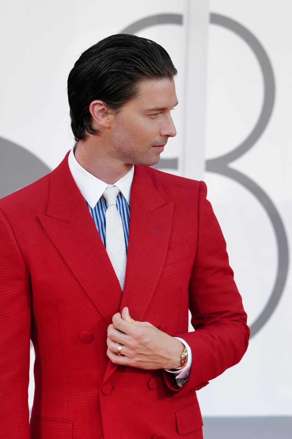 Patrick Schwarzenegger profile close-up in red suit, Venice Film Festival 2026 – Ph. Barbara Pigazzi, Studio Animica
