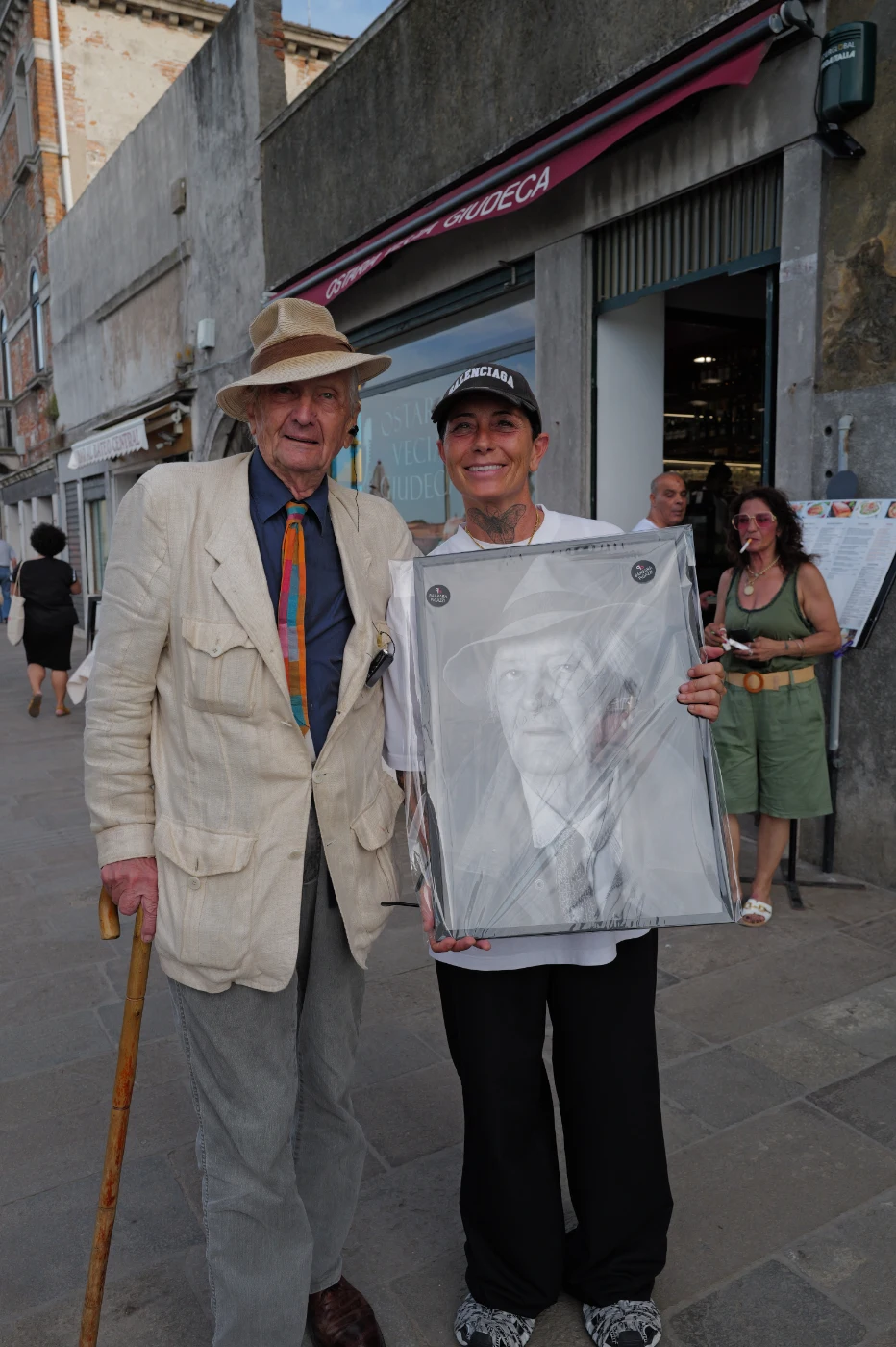 Italo Zannier and Barbara Pigazzi with the framed portrait on the Giudecca, Venice